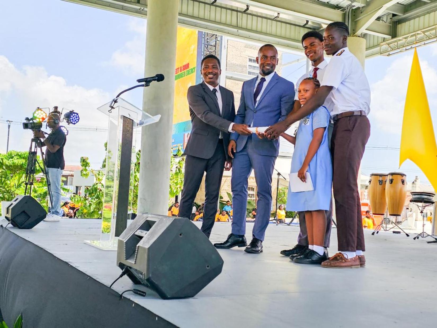 Students deliver a declaration on behalf of children of Barbados for World Children's Day to Minister of the Environment, National Beautification and the Green and Blue Economy Adrian Forde. 