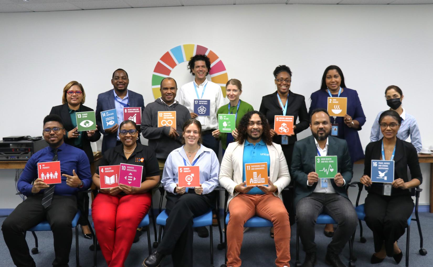 A group of people hold up posters of the Sustainable Development Goals (SDGs)