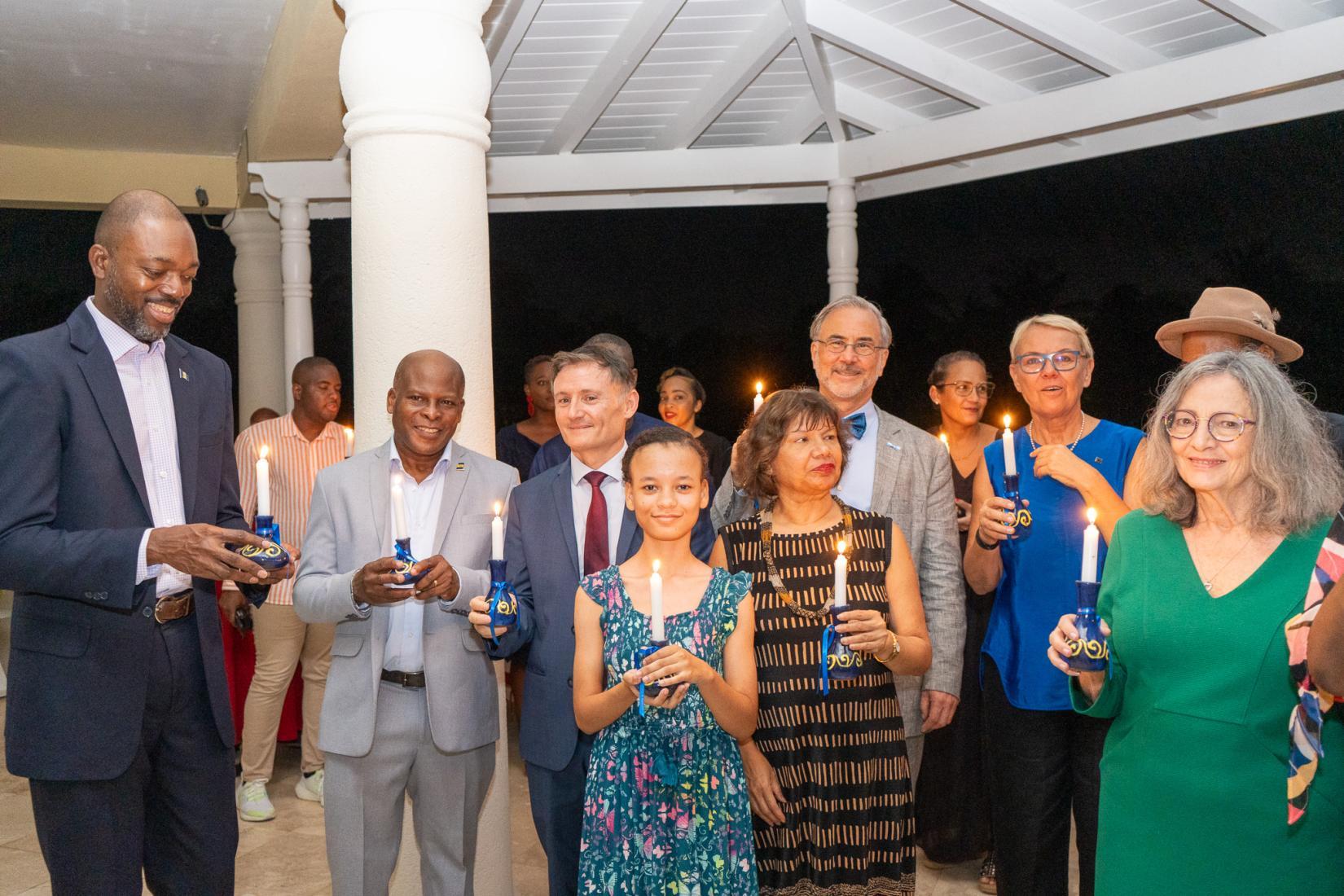 Agroup of people hold candles in honour of human rights defenders