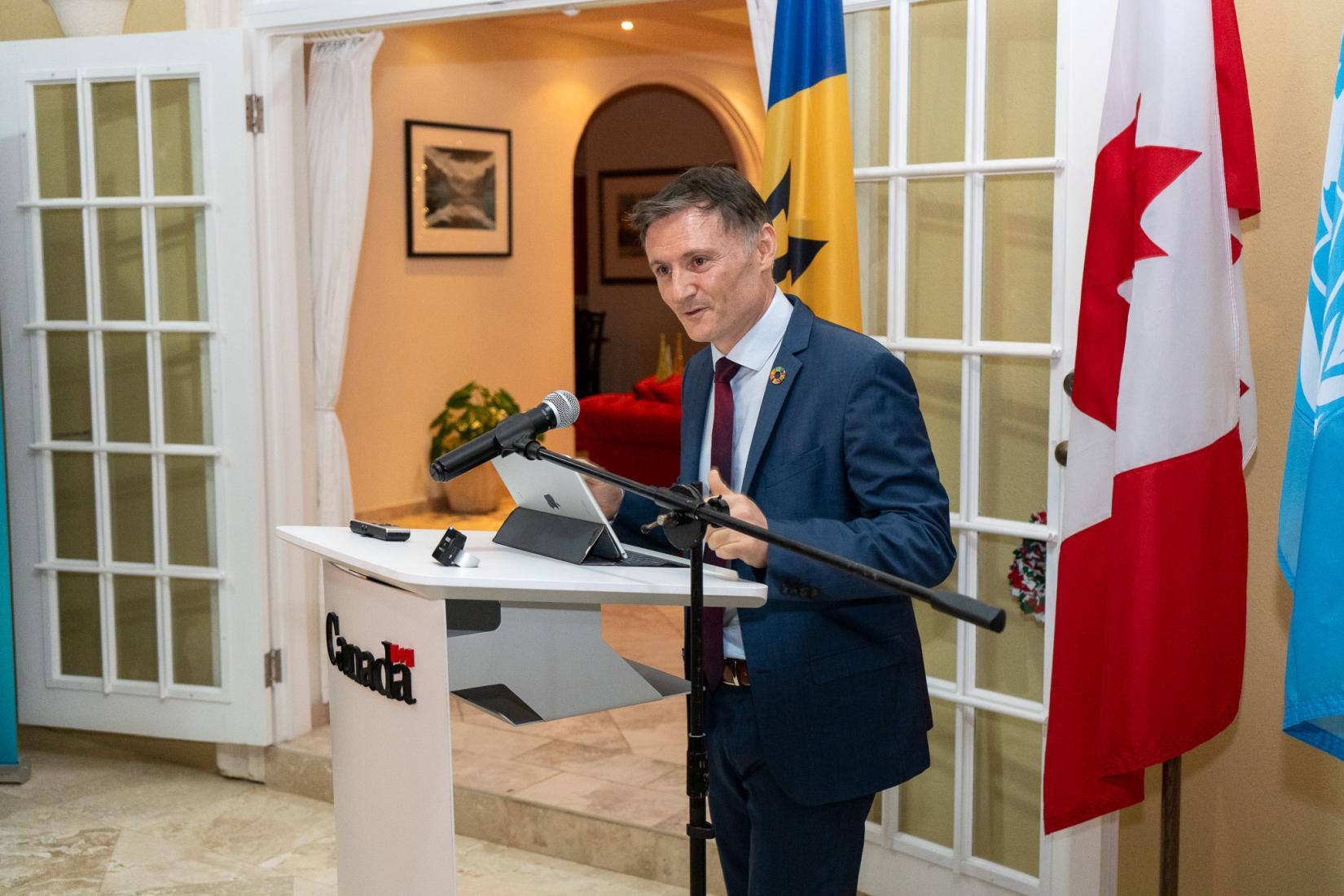 Didier Trebucq, UN Resident Coordinator for Barbados and Eastern Caribbean Countries and territories (L) The Hon. Natalio Wheatley, British Virgin Islands Premier and Minister for Tourism, Culture and Sustainable Development delivers address at a podium