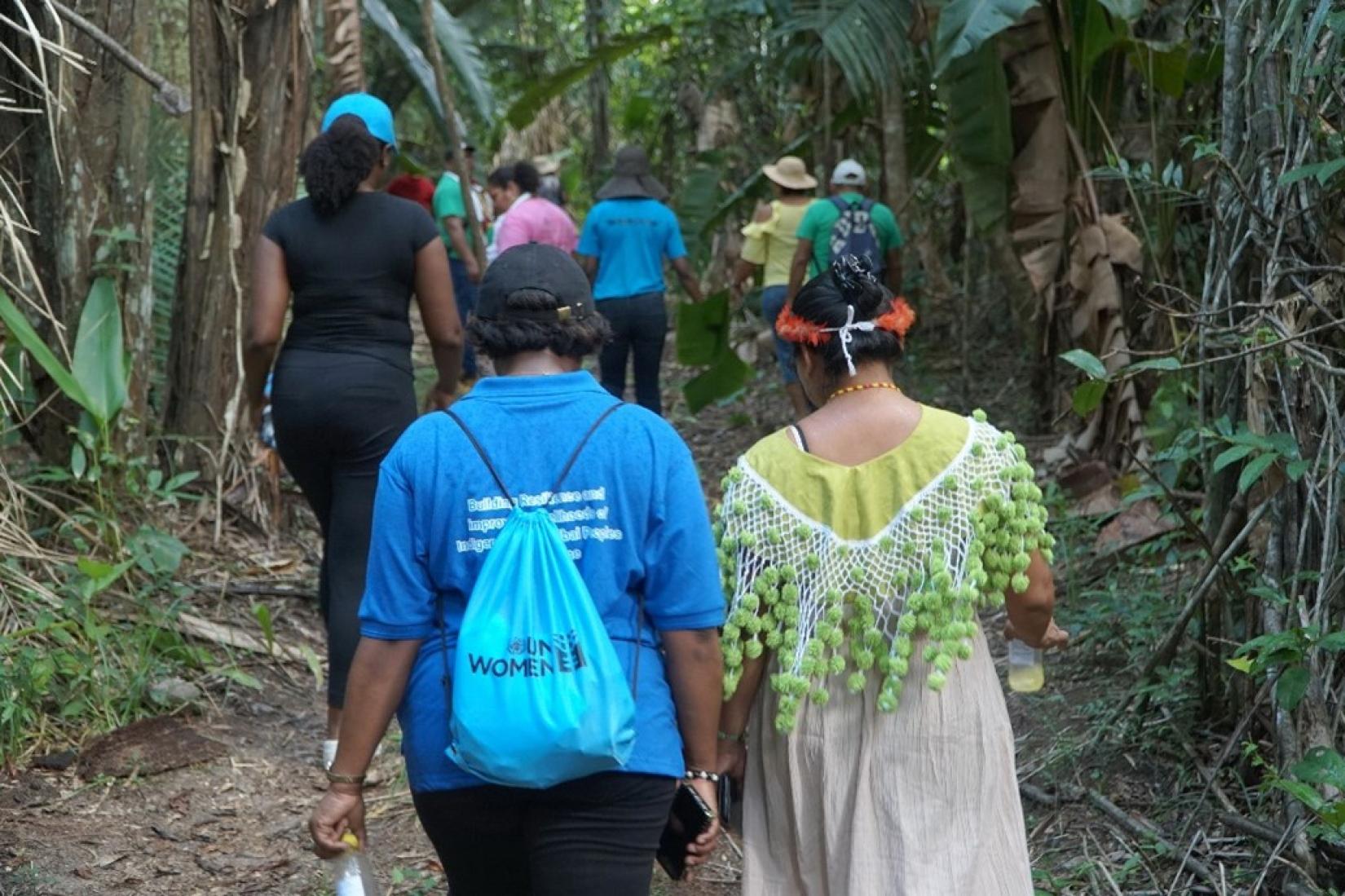 A member of an Indigenous community walks alongside a UN Women representative.