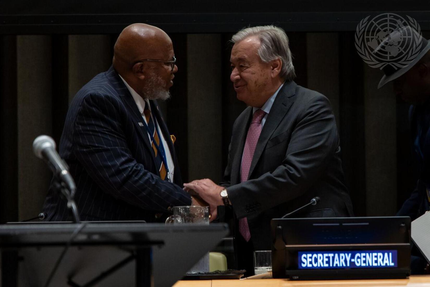 Secretary-General António Guterres (right) speaks with Dennis Francis, Former President of the of the General Assembly, before the opening and plenary segment of the High-level plenary meeting of the General Assembly on the theme "Addressing the threats posed by sea level rise".