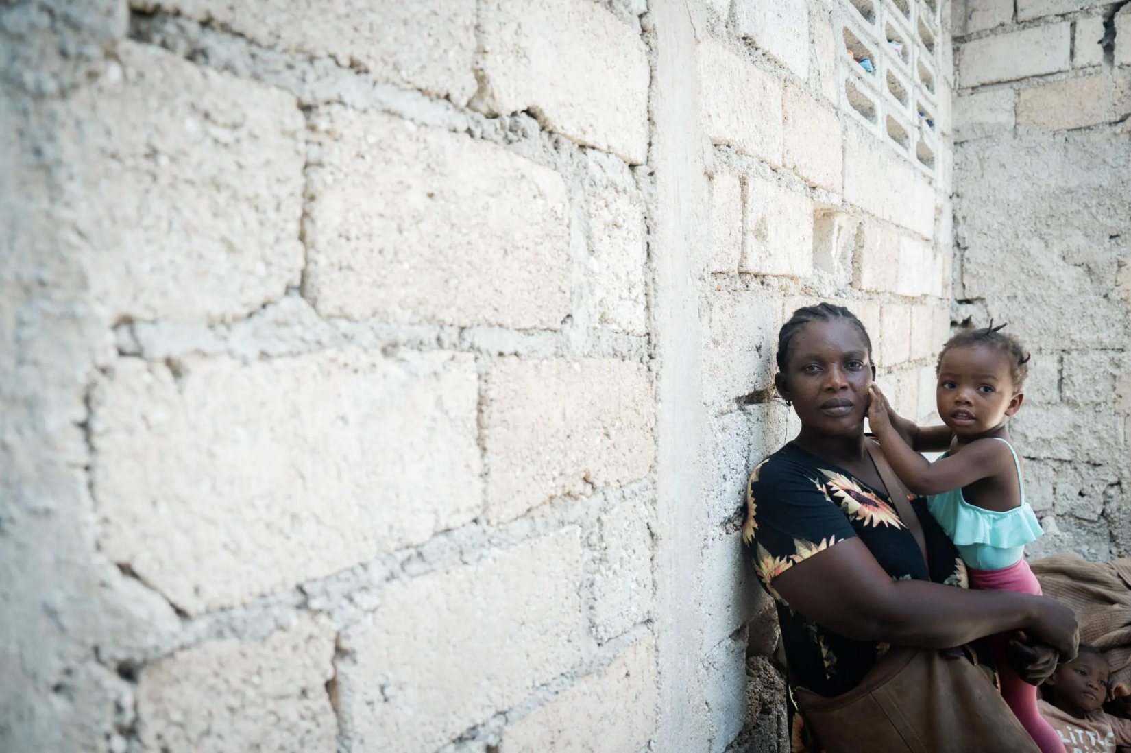 A mother holds her child in an improvised displacement site in Léogâne, Haiti