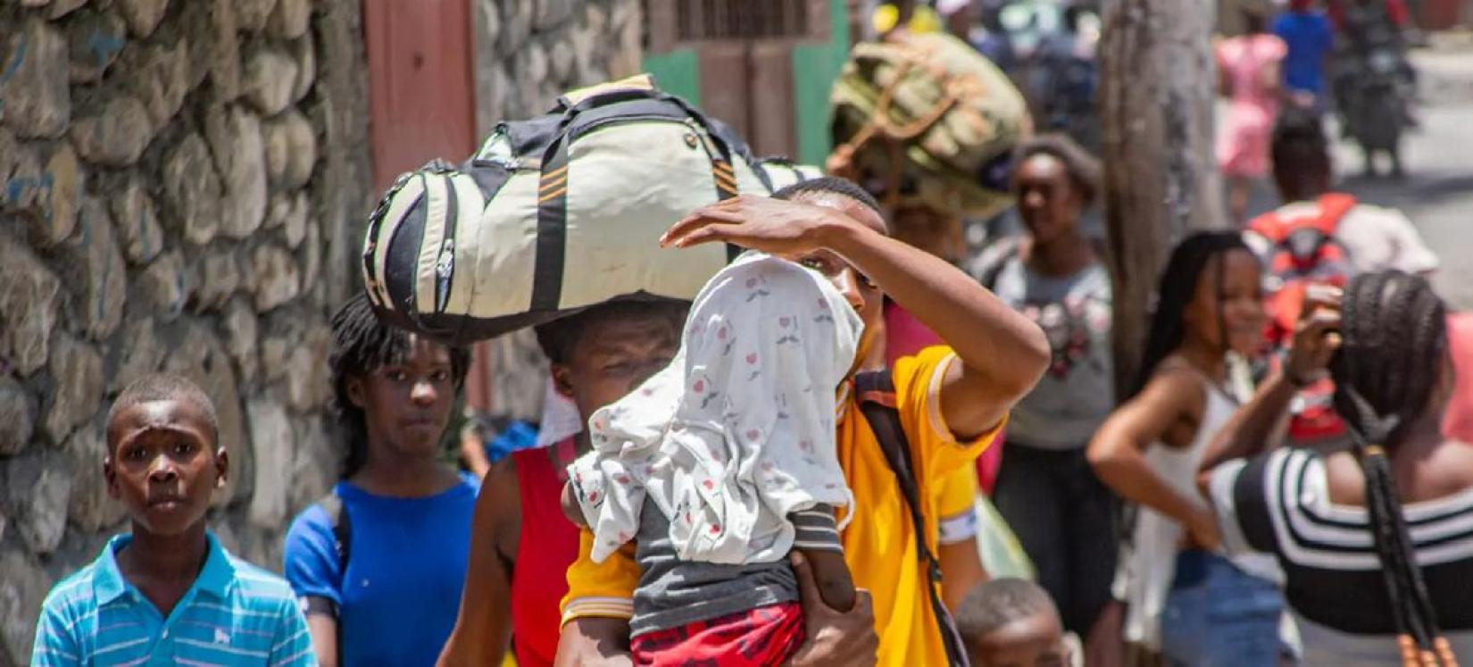 Displaced by escalating violence, families in Haiti carry their belongings as they flee their homes in search of safety.