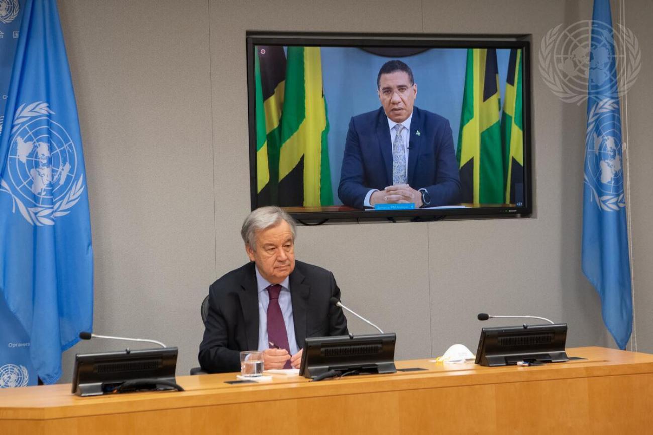 Secretary-General António Guterres (seated) briefs reporters together with Andrew Holness (on screen), Prime Minister of Jamaica, and Justin Trudeau (not pictured), Prime Minister of Canada, on the meeting on "Financing for Development in the Era of COVID-19 and Beyond".