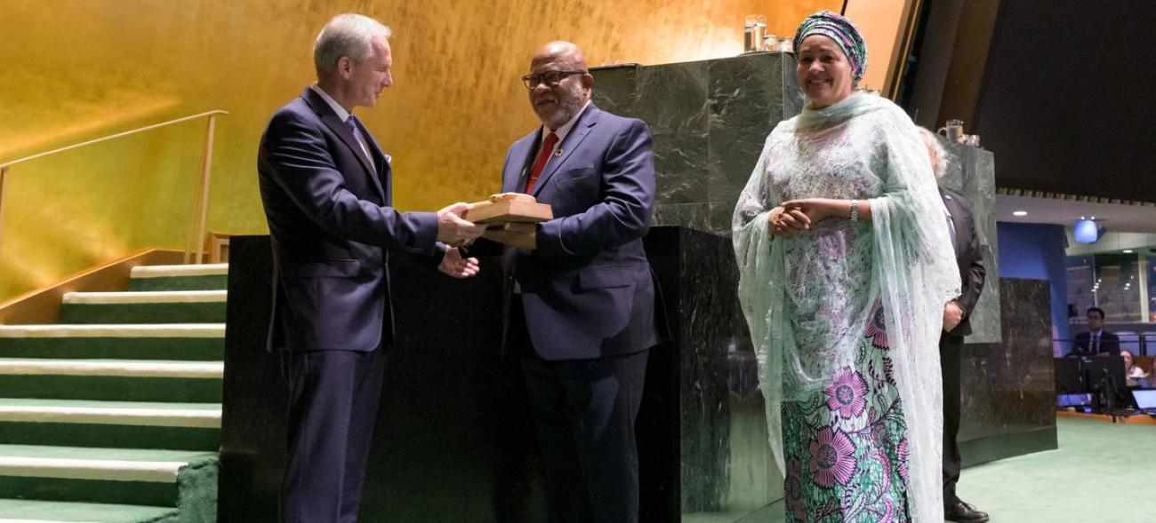 Csaba Kőrösi (left), President of the 77th session of the UN General Assembly, hands the gavel over to Dennis Francis, President of the 78th session.