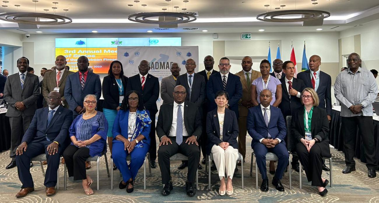 A group photo is shown featuring participatns at a meeting in Saint Lucia where Caribbean States committed to reducing illicit firearms flow across the region
