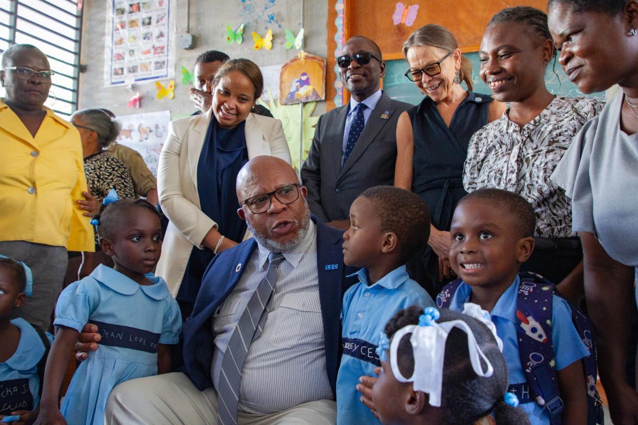 UNGA President Dennis Francis sits with children from Haiti