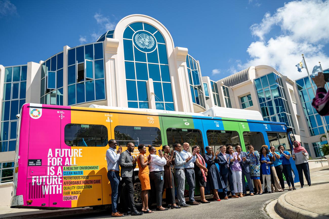 A photo of UN colleagues and project partners standing together celebrating the SDG bus launch. 