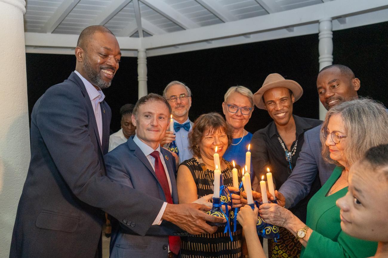 A group of people hold candles in honour of human rights heroes