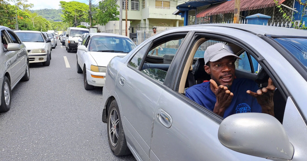 A man gestures in frustration from inside of his vehicle in response to traffic congestion