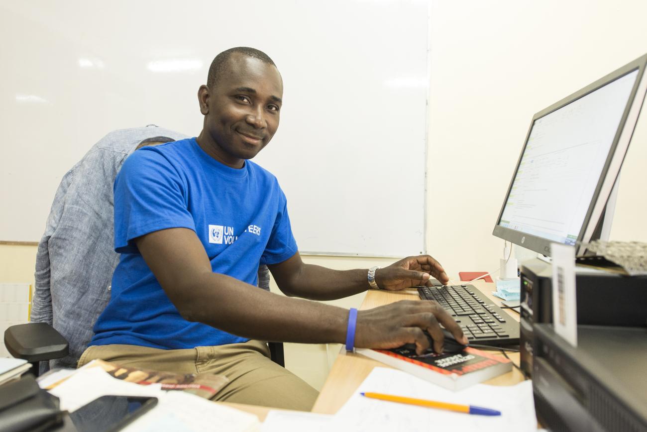 A UN Volunteer works at a compute rin an office setting