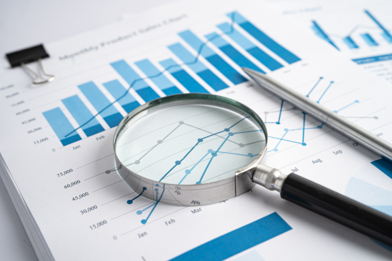 Magnifying Glass on Charts Graphs Paper. 