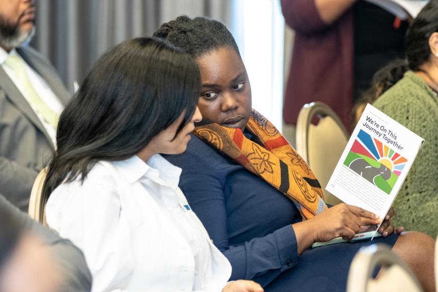 Attendees read the Snapshots of Success magazine featuring highlights of the UN Country Team's 2022 deliverables.