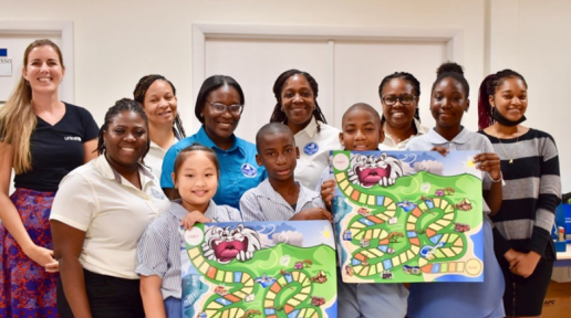 Representatives of Student Support Services Division & UNICEF the Netherlands with 5th-grade students, teachers, and administrators at Asha Stevens Christian Hillside School. The artwork for the game is created by Artistic Drive and inspired by SSSD’s Student Safety Ambassador Program.