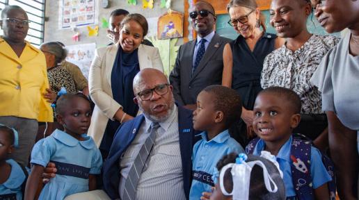 UNGA President Dennis Francis sits with children from Haiti