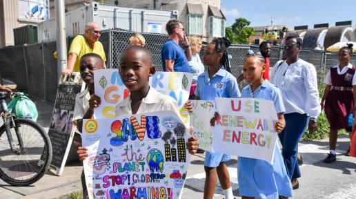 Children Carry Signs calling for climate action at a rally in Bridgetown Barbados for World Childrens Day