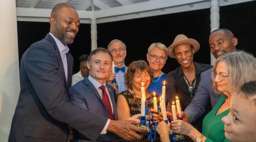 A group of people hold candles in honour of human rights heroes