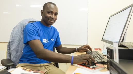 A UN Volunteer works at a compute rin an office setting