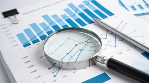 Magnifying Glass on Charts Graphs Paper. 